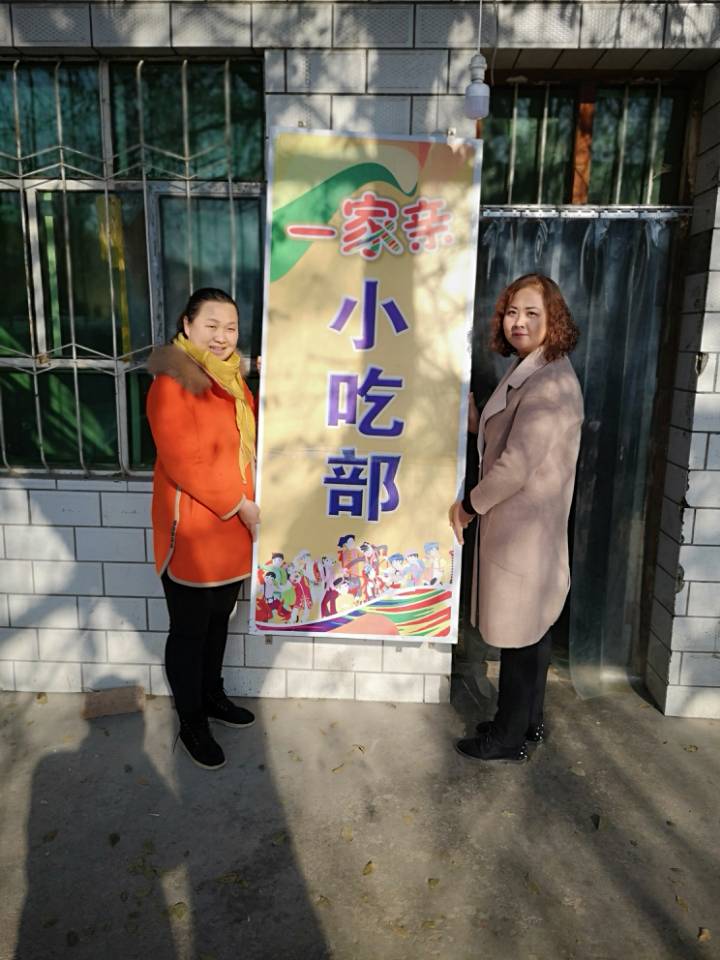 姜辉（左）和饺子馆老板娘禹香燕展示店招牌。.jpg